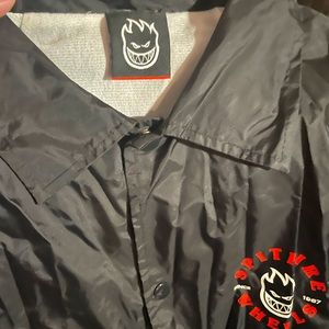 Black, red and white Spitfire windbreaker button up jacket. Side pockets.